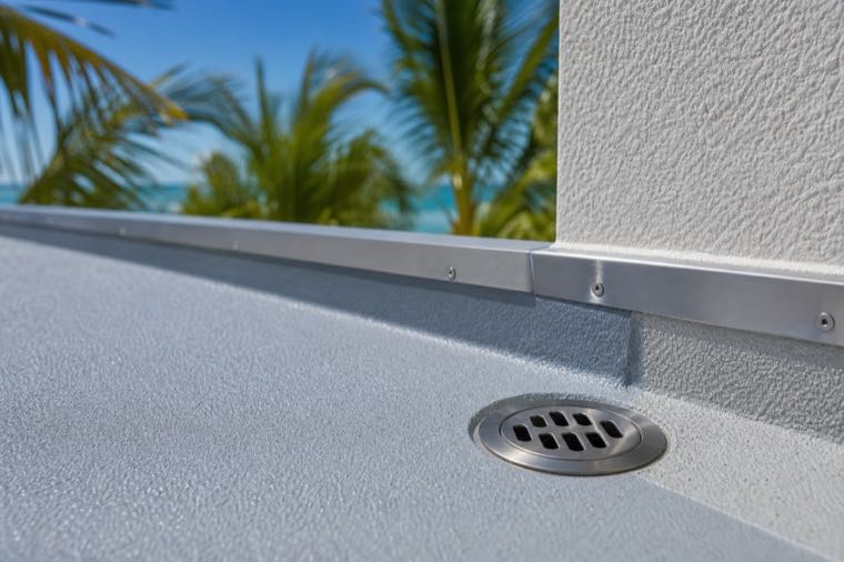Detail of a waterproof walkable deck system at an edge and drain.